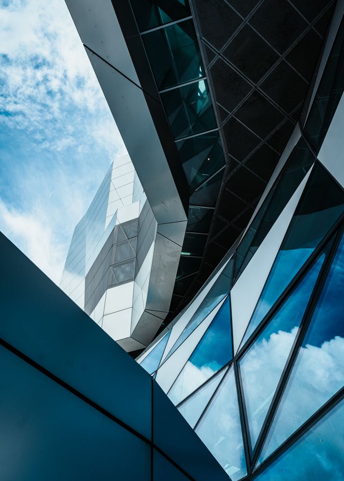 get-in-touch A captivating view of modern architecture with reflective glass surfaces and a clear sky backdrop.